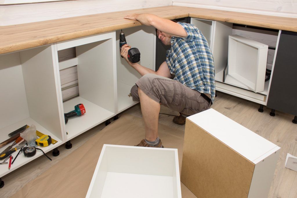 Furniture assembler assembles kitchen furniture in a private house