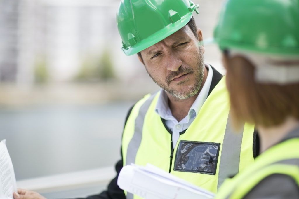 Manager and foreman discussing construction project on site