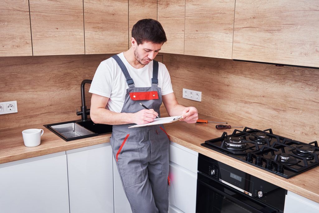 Plumber signs a contract for the services in the kitchen